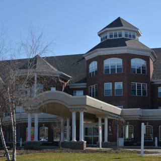 A large multi-story brick building with a prominent entrance and unique architectural features.