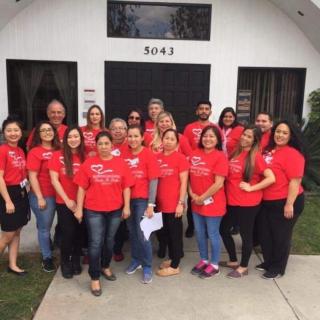 A group of people wearing red shirts standing in front of a building.