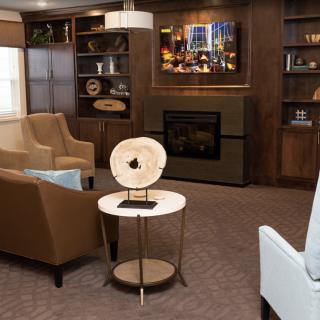 A cozy living room featuring a modern fireplace, stylish furniture, and decorative elements.