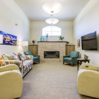 A cozy living room featuring a fireplace, comfortable seating, and a mounted TV.