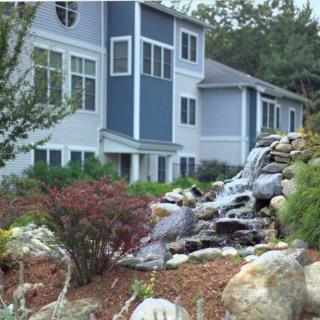 A modern house with a beautifully landscaped garden featuring a cascading waterfall.