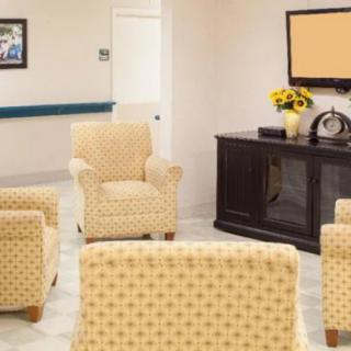 A cozy living room with patterned armchairs facing a television.