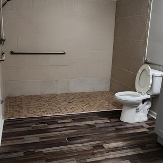 A modern accessible bathroom with a roll-in shower.