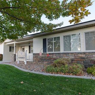 A suburban house with a well-maintained lawn and landscaped garden.