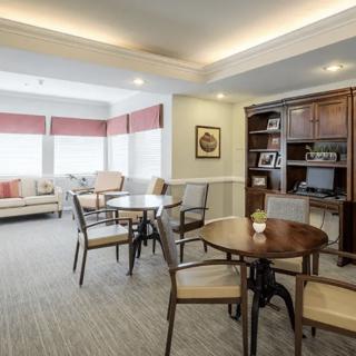 A cozy living area with multiple seating arrangements and a bookshelf.