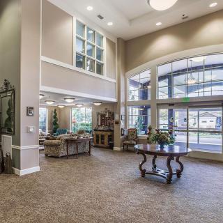 A spacious and elegantly decorated lobby with large windows and comfortable seating.