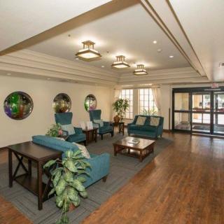 A spacious lobby area featuring comfortable seating, decorative plants, and modern lighting fixtures.