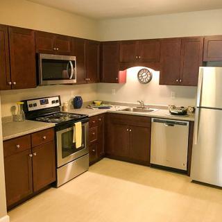 A modern kitchen with stainless steel appliances and wooden cabinets.