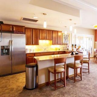 A modern kitchen with wooden cabinets, an island counter, and stainless steel appliances.