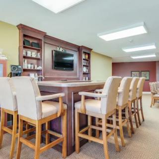 An indoor bar area with high chairs and a television mounted on the wall.