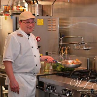 A chef cooking in a professional kitchen.