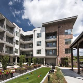 A modern apartment complex with balconies and landscaped outdoor areas.
