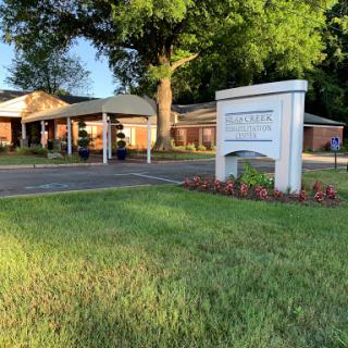 A welcoming view of a facility with lush green surroundings.