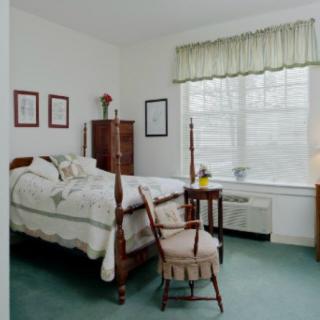 A cozy bedroom with classic wooden furniture and a large window.