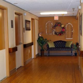 A cozy hallway featuring a waiting area with a comfortable couch and decorative elements.