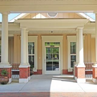 A front entrance of a building with columns and a covered porch.