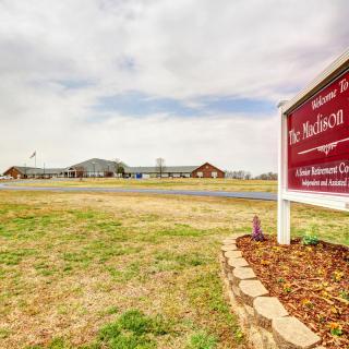 An outdoor view of a school with a sign in the foreground.