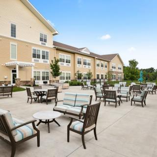 Outdoor patio area with seating in front of a residential building.