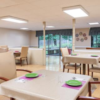 A bright and inviting dining area with neatly arranged tables and comfortable seating.