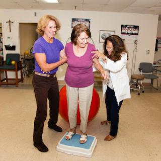 Healthcare professionals assist an individual during a balance training session.