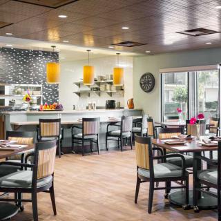 A modern restaurant dining area featuring stylish furnishings and a well-lit bar.