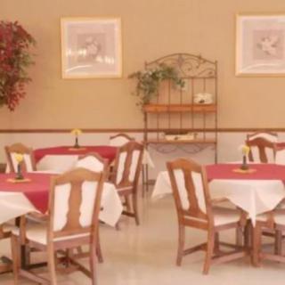 A cozy dining area with tables and chairs, featuring pleasant decor.