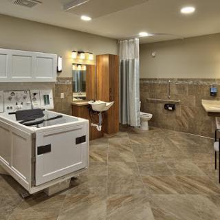 A modern bathroom featuring laundry facilities, complete with a toilet, sink, and shower.