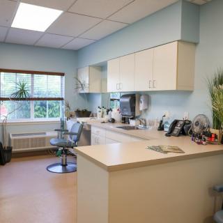 A clean and well-organized dental office with equipment and a chair.