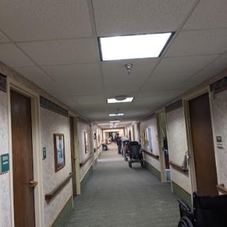 A view down a well-lit corridor with doors lining the walls.