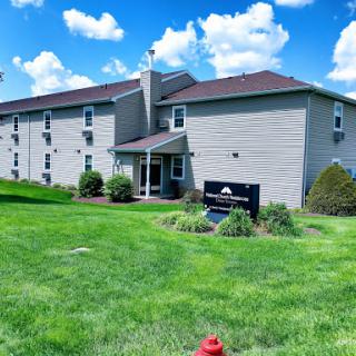A sunny day showcasing a modern building surrounded by lush green grass under a bright blue sky.