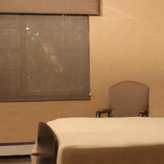 A quiet room with a bed, chair, and closed window blinds.