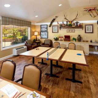A cozy meeting room with conference tables and chairs, decorated with wall art, antlers, and a model airplane.