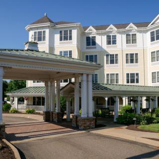 A large hotel building with a covered driveway entrance and well-maintained landscaping.
