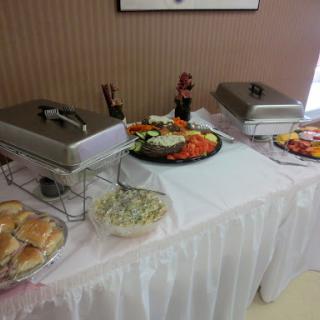 A beautifully arranged buffet table with a variety of dishes including salads, vegetables, and baked goods.