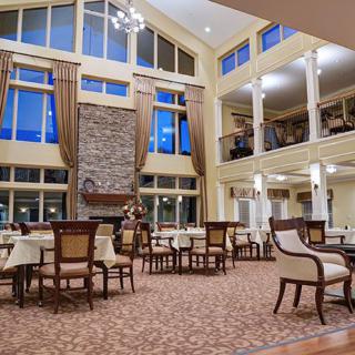 A spacious dining area with high ceilings, large windows, and elegant decor.