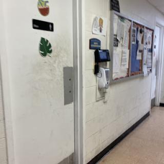 A hallway featuring a door with decorations and a bulletin board filled with various notices.