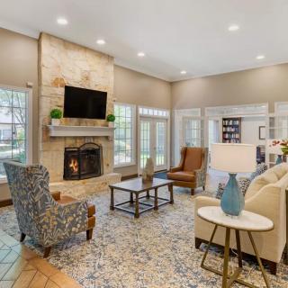 A modern and cozy living room with a fireplace, stylish furniture, and a mounted television.