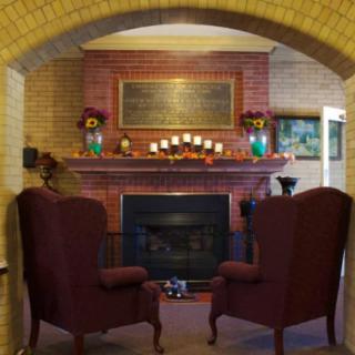 A cozy living room with a fireplace and two armchairs.