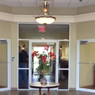 A welcoming lobby entrance with a floral arrangement on a table and a chandelier overhead.