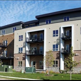 A modern apartment building with multiple balconies in a residential area.