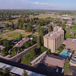 Aerial view of a residential area with buildings, trees, and a swimming pool.