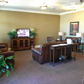 A cozy waiting room featuring comfortable seating and a television for entertainment.
