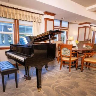A cozy living room featuring a grand piano and elegant furniture.