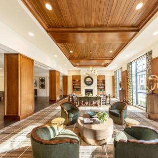 A luxurious living room with a wooden ceiling, modern furnishings, and ample natural light.