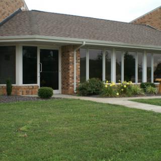 A charming single-story residential building with a landscaped front yard.
