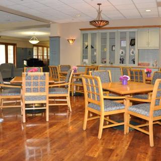 A spacious dining area with wooden furniture and elegant lighting.