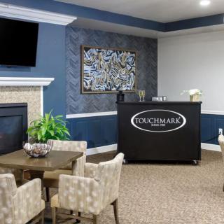 A modern living room interior featuring a seating area, fireplace, and decorative wall art.