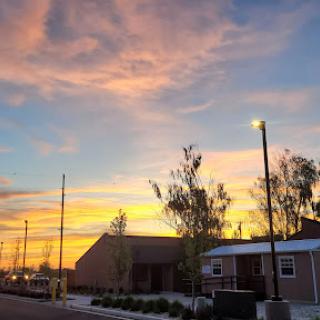 A beautiful sunset paints the sky with vibrant colors behind a serene neighborhood.