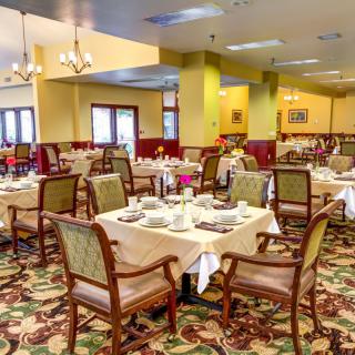 An elegantly arranged dining room with neatly set tables and chairs.