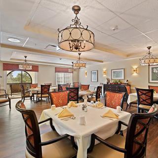 An elegant restaurant dining room with well-arranged tables and stylish chandeliers.